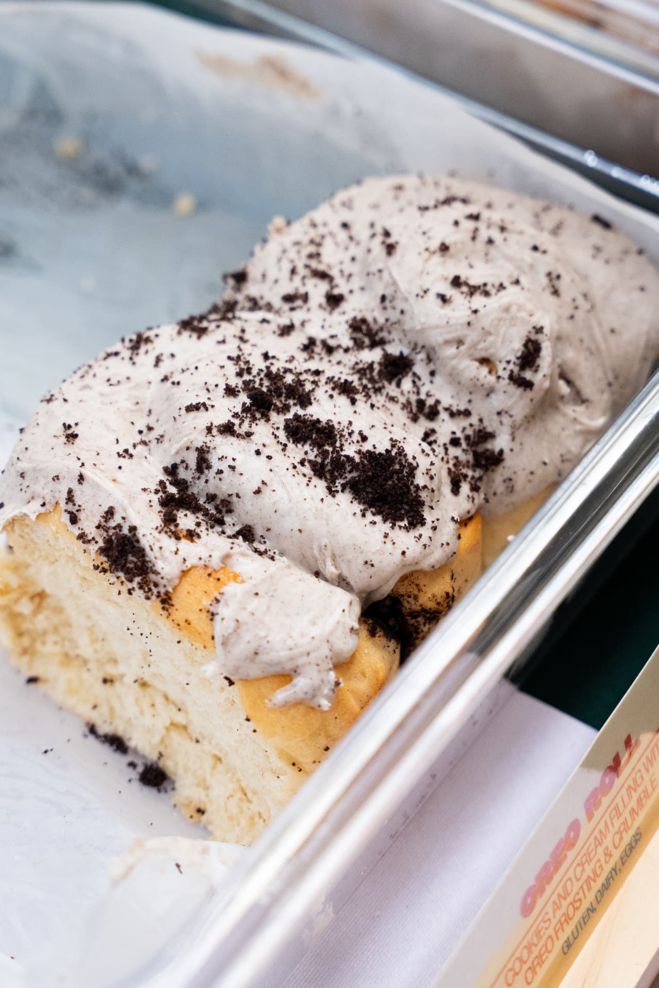Oreo roll topped with cookies and cream frosting and crumble